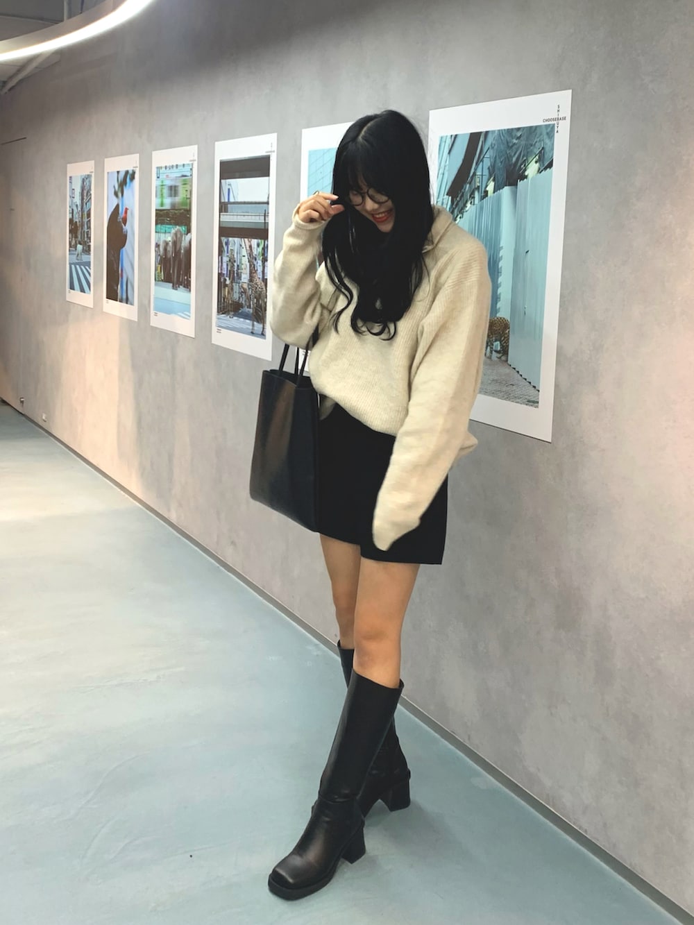 ブラック系のブーツ、ベージュ系のニット/セーター、ブラック系のパンツを着用したレディースの冬コーディネートの2枚目の写真