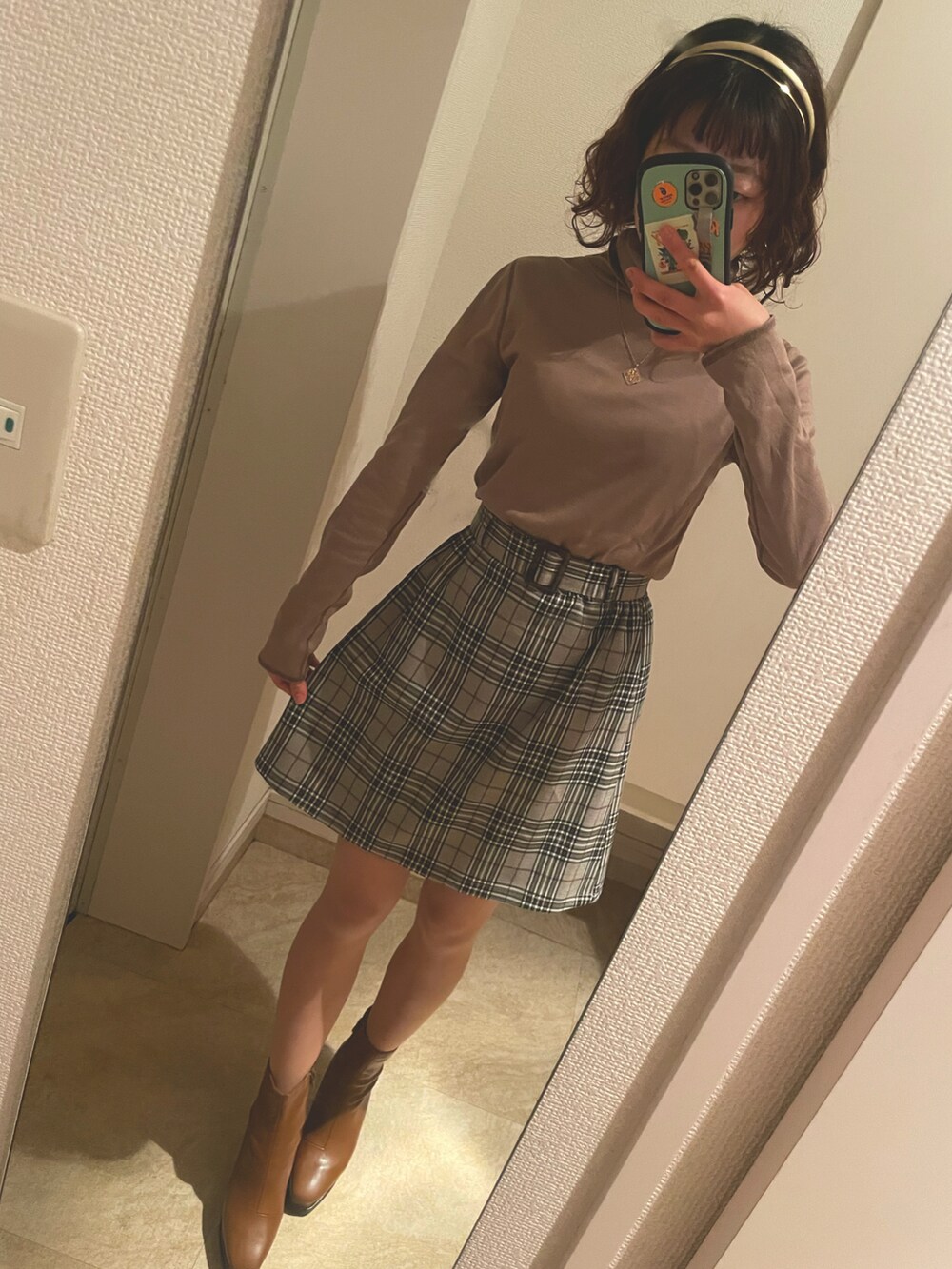 イエロー系のブーツ、ベージュ系のTシャツ/カットソー、グレー系のスカートを着用したレディースの秋コーディネートの3枚目の写真