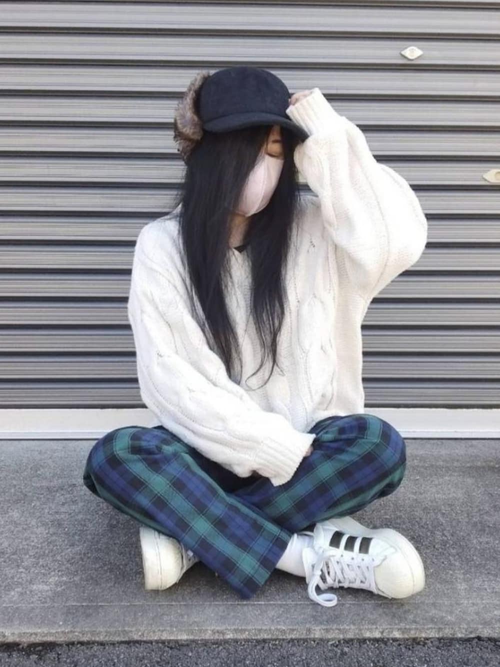 ホワイト系のスニーカー、ホワイト系のニット/セーター、グリーン系のチノパンツを着用したレディースの冬コーディネートの2枚目の写真