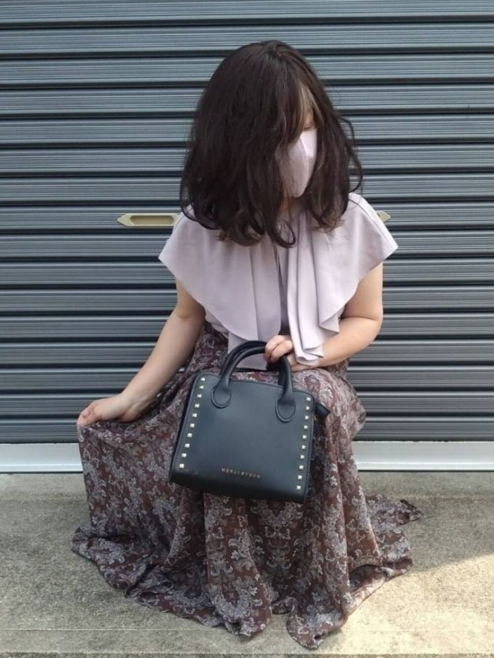 ブラック系のサンダル、ブラウン系のスカートを着用したレディースの夏コーディネートの2枚目の写真