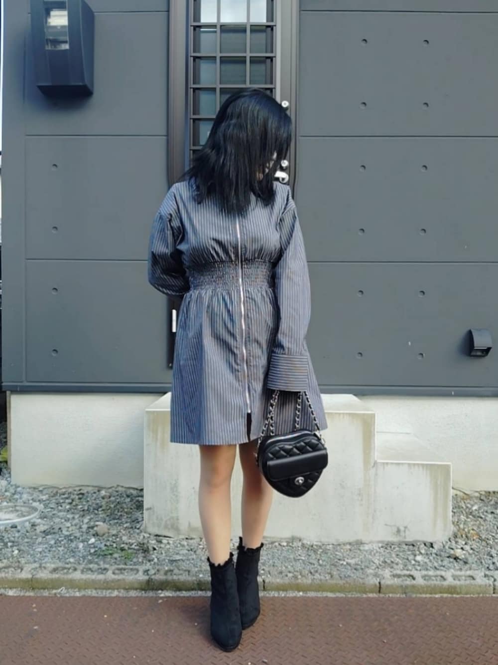 グレー系のシャツワンピース、ブラック系のショルダーバッグ、ブラック系のブーツを着用したレディースの秋コーディネートの2枚目の写真