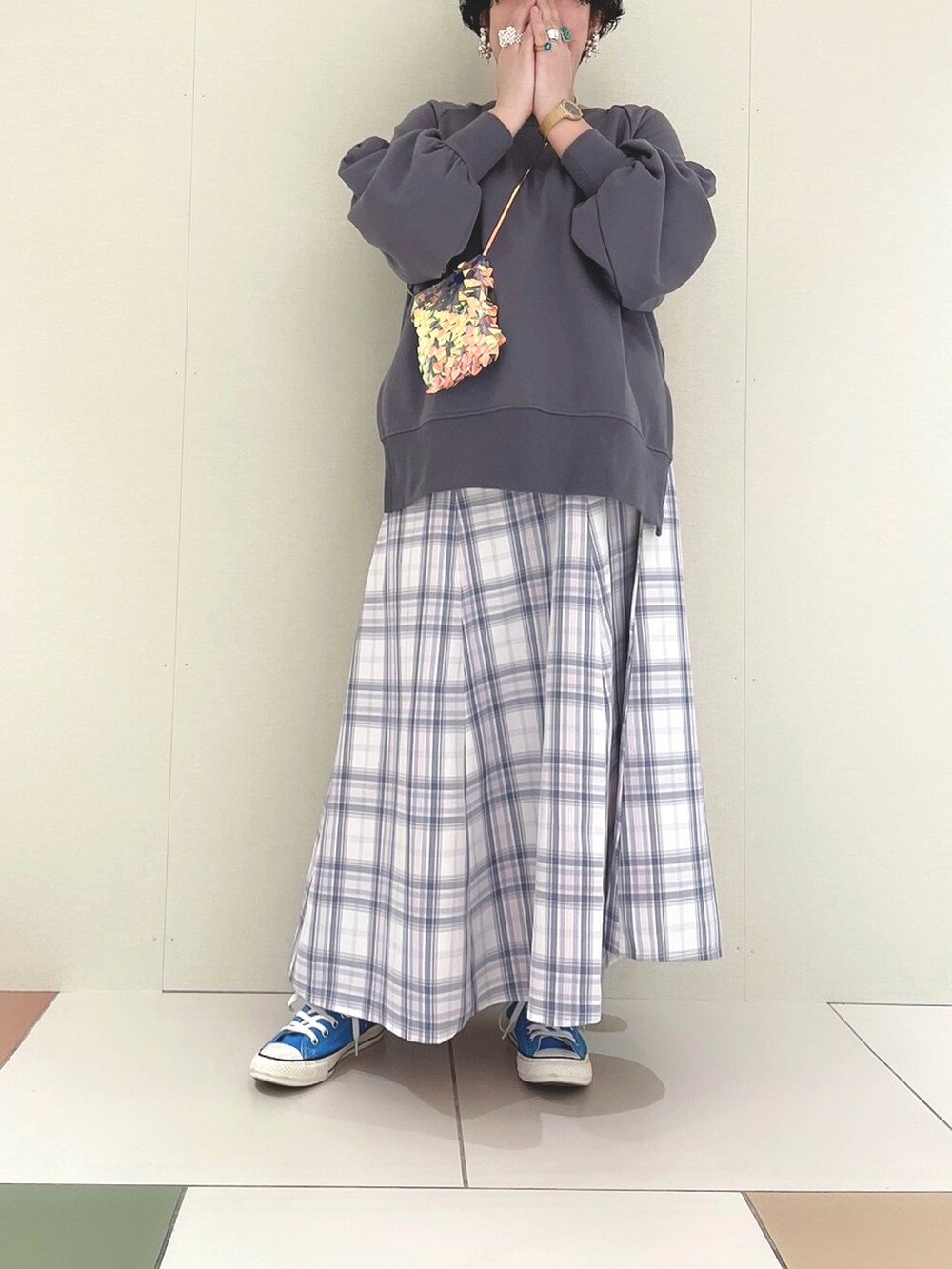 ブルー系のカーディガン/ボレロ、ブルー系のスカート、ブルー系のスニーカーを着用したレディースの春コーディネートの2枚目の写真