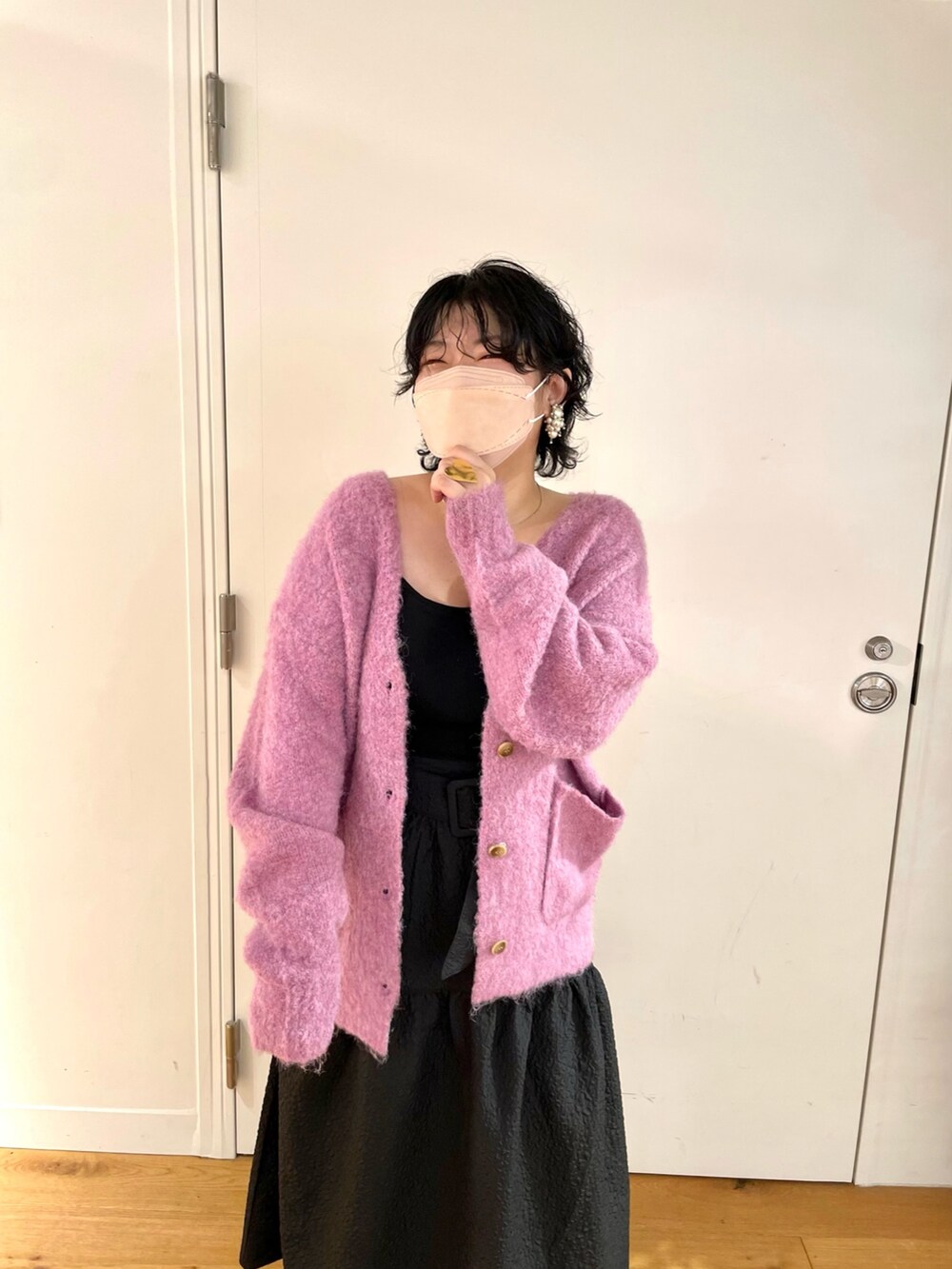 ピンク系のカーディガン/ボレロ、ブラック系のスカート、ブラック系のブーツを着用したレディースの秋コーディネートの2枚目の写真