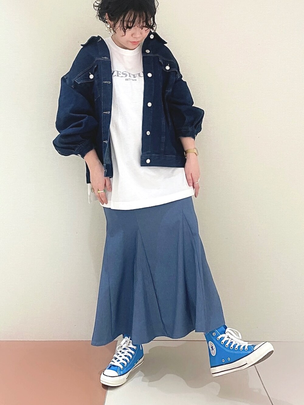 ブルー系のデニムジャケット、ホワイト系のTシャツ/カットソー、ブルー系のスカートを着用したレディースの春コーディネートの2枚目の写真