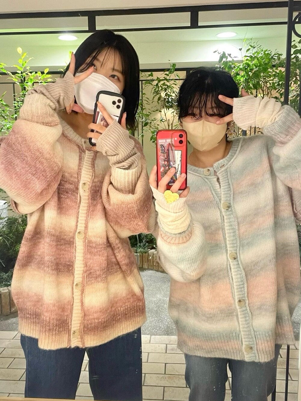 ピンク系のカーディガン/ボレロ、ブルー系のデニムパンツ、ホワイト系の手袋を着用したレディースの秋コーディネートの2枚目の写真