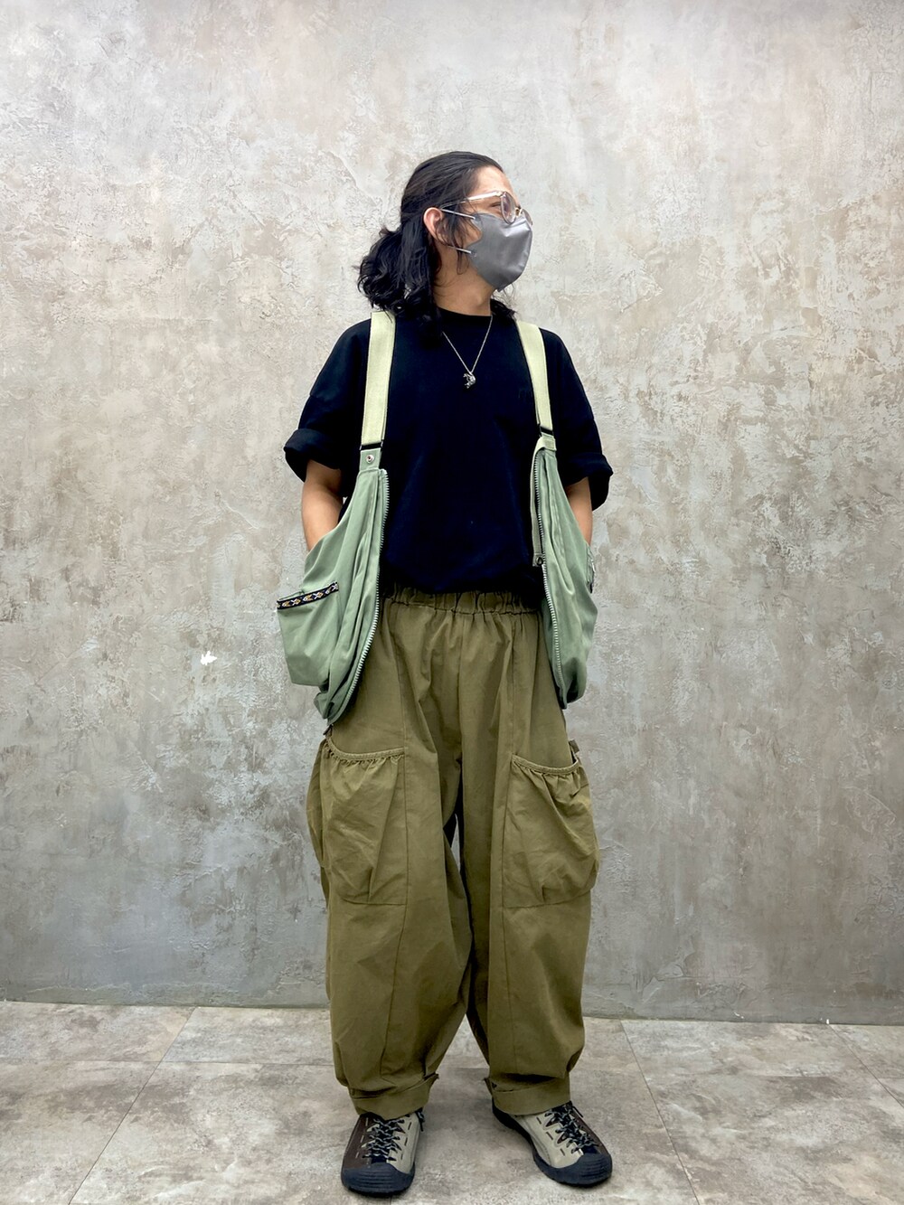 ブラック系のTシャツ/カットソー、グリーン系のその他パンツ、グレー系のシューズを着用したメンズの秋コーディネートの2枚目の写真