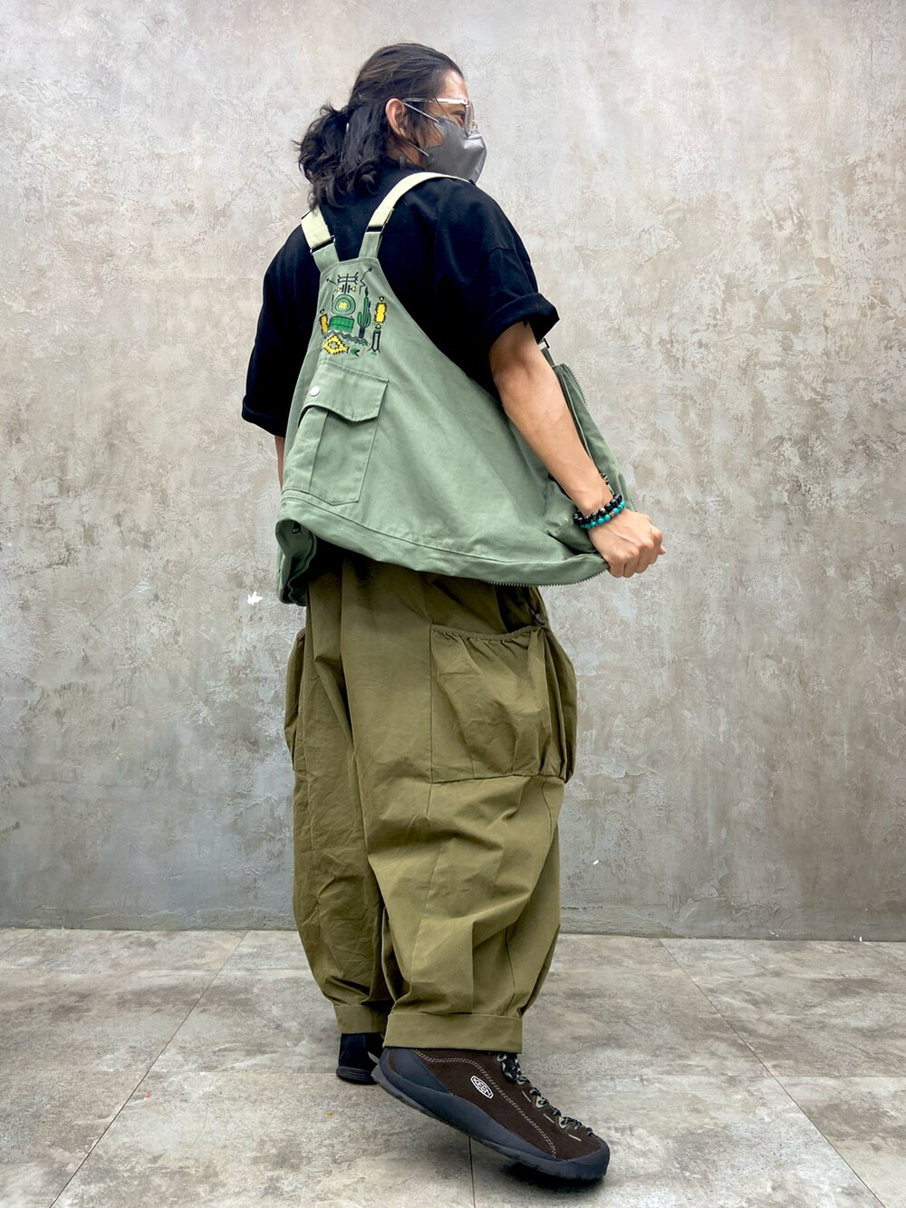 ブラック系のTシャツ/カットソー、グリーン系のその他パンツ、グレー系のシューズを着用したメンズの秋コーディネートの3枚目の写真