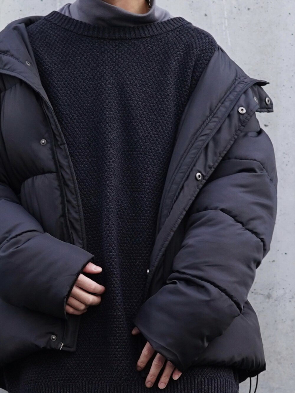 ブラック系のダウンジャケット/コート、グレー系のカーディガン/ボレロ、グレー系のTシャツ/カットソーを着用したメンズの冬コーディネートの2枚目の写真