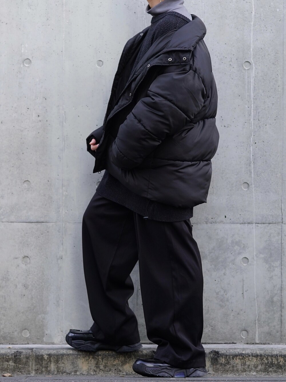 ブラック系のダウンジャケット/コート、グレー系のカーディガン/ボレロ、グレー系のTシャツ/カットソーを着用したメンズの冬コーディネートの3枚目の写真