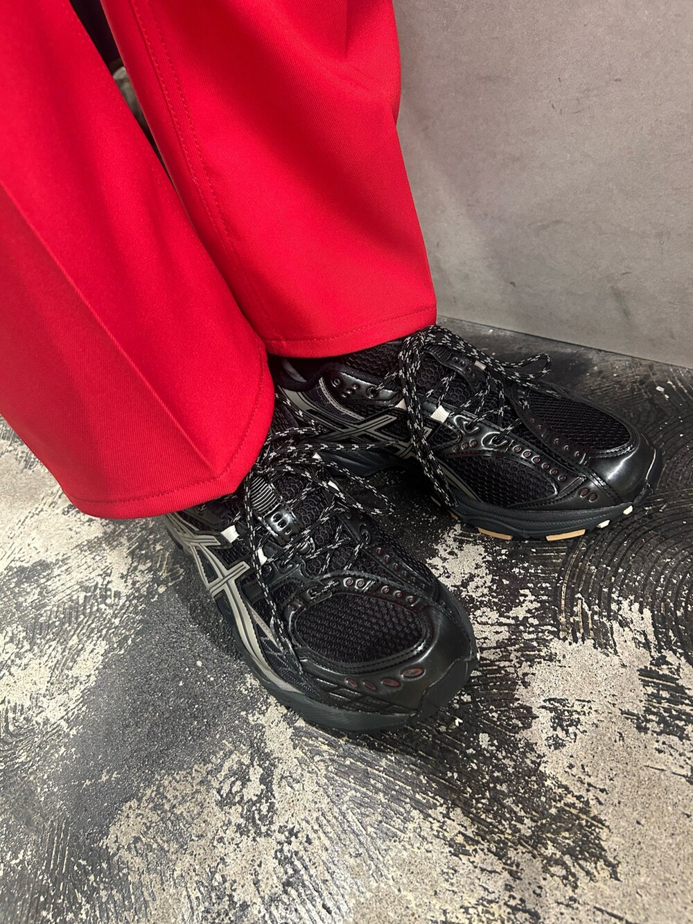 ブラック系のカーディガン/ボレロ、レッド系のその他パンツ、ブラック系のスニーカーを着用したメンズの春コーディネートの2枚目の写真