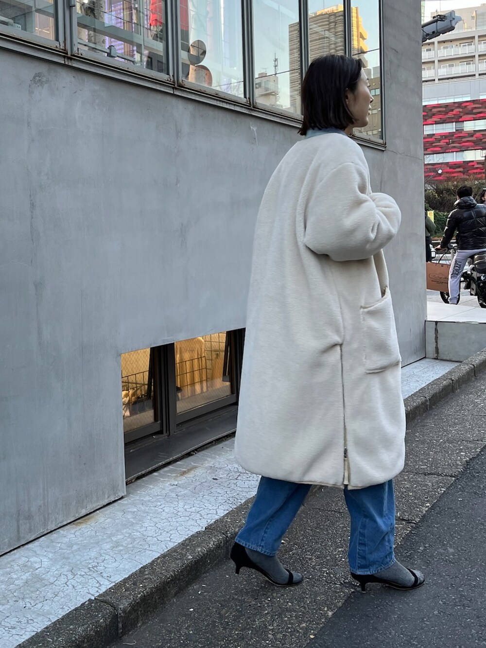 ベージュ系のダウンジャケット/コート、ブルー系のシャツ/ブラウス、ブルー系のニット/セーターを着用したレディースの冬コーディネートの4枚目の写真
