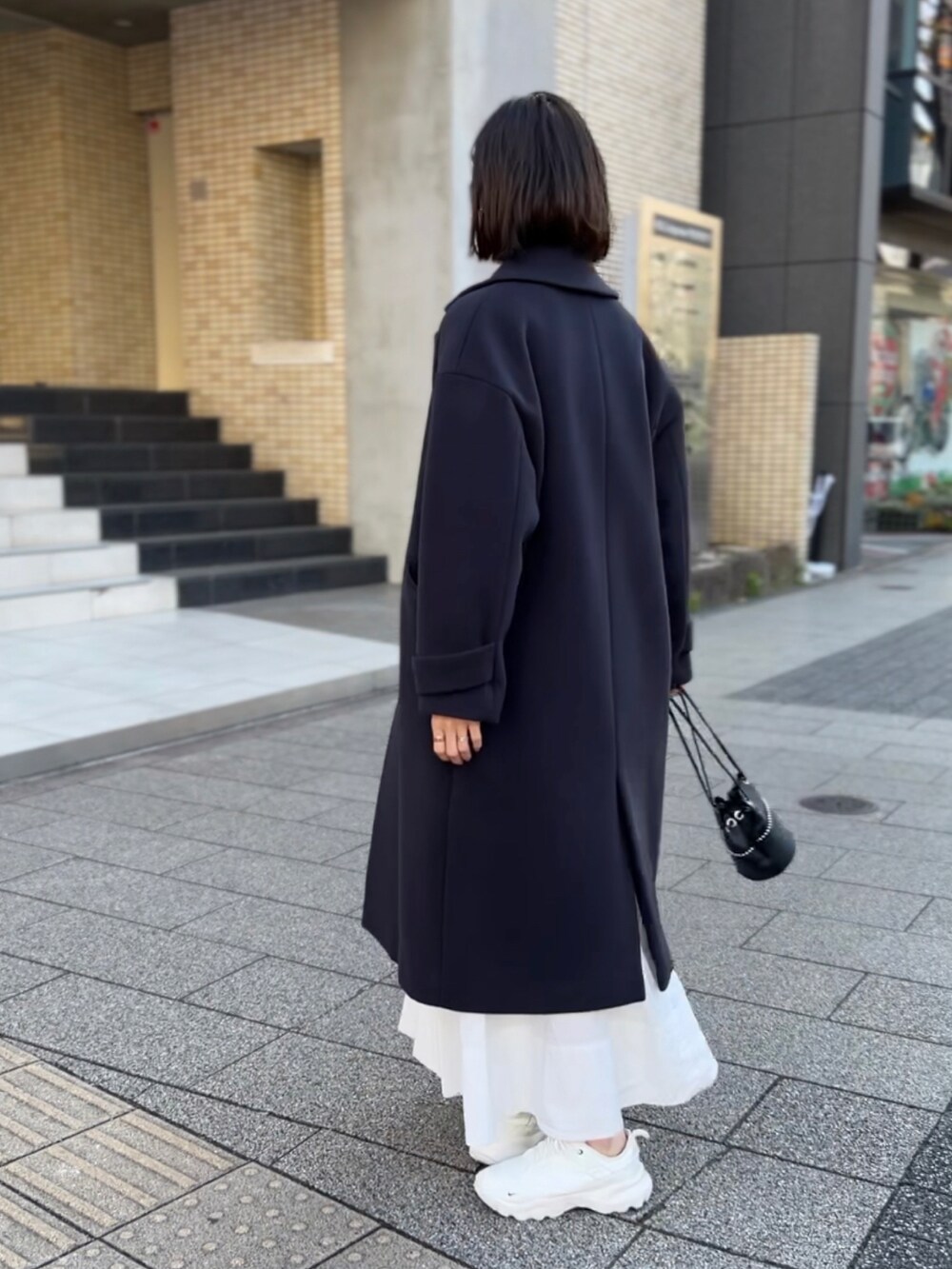 ブルー系のチェスターコート、グレー系のニット/セーター、ブルー系のシャツ/ブラウスを着用したレディースの冬コーディネートの4枚目の写真