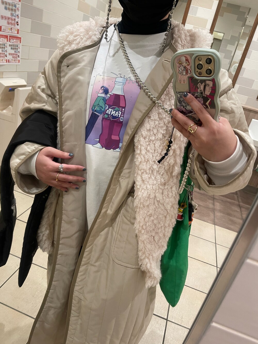 ベージュ系のノーカラーコート、ブラック系のダウンジャケット/コート、ホワイト系のベストを着用したレディースの冬コーディネートの2枚目の写真