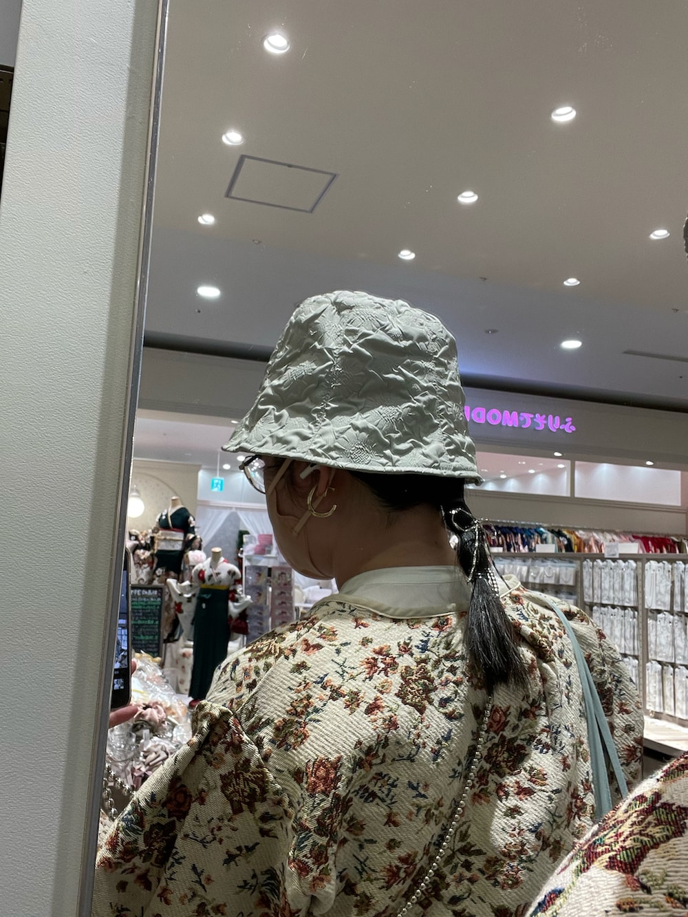 ホワイト系のカーディガン/ボレロ、ホワイト系のワンピース、グリーン系のスラックスを着用したレディースの春コーディネートの2枚目の写真