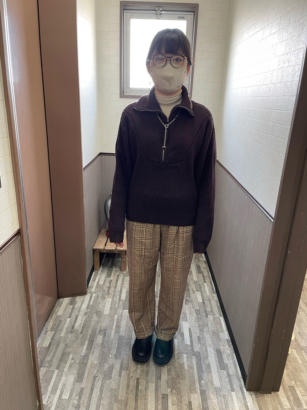 グレー系のダウンジャケット/コート、ベージュ系のカーゴパンツ、ブラック系のブーツを着用したレディースの冬コーディネートの2枚目の写真