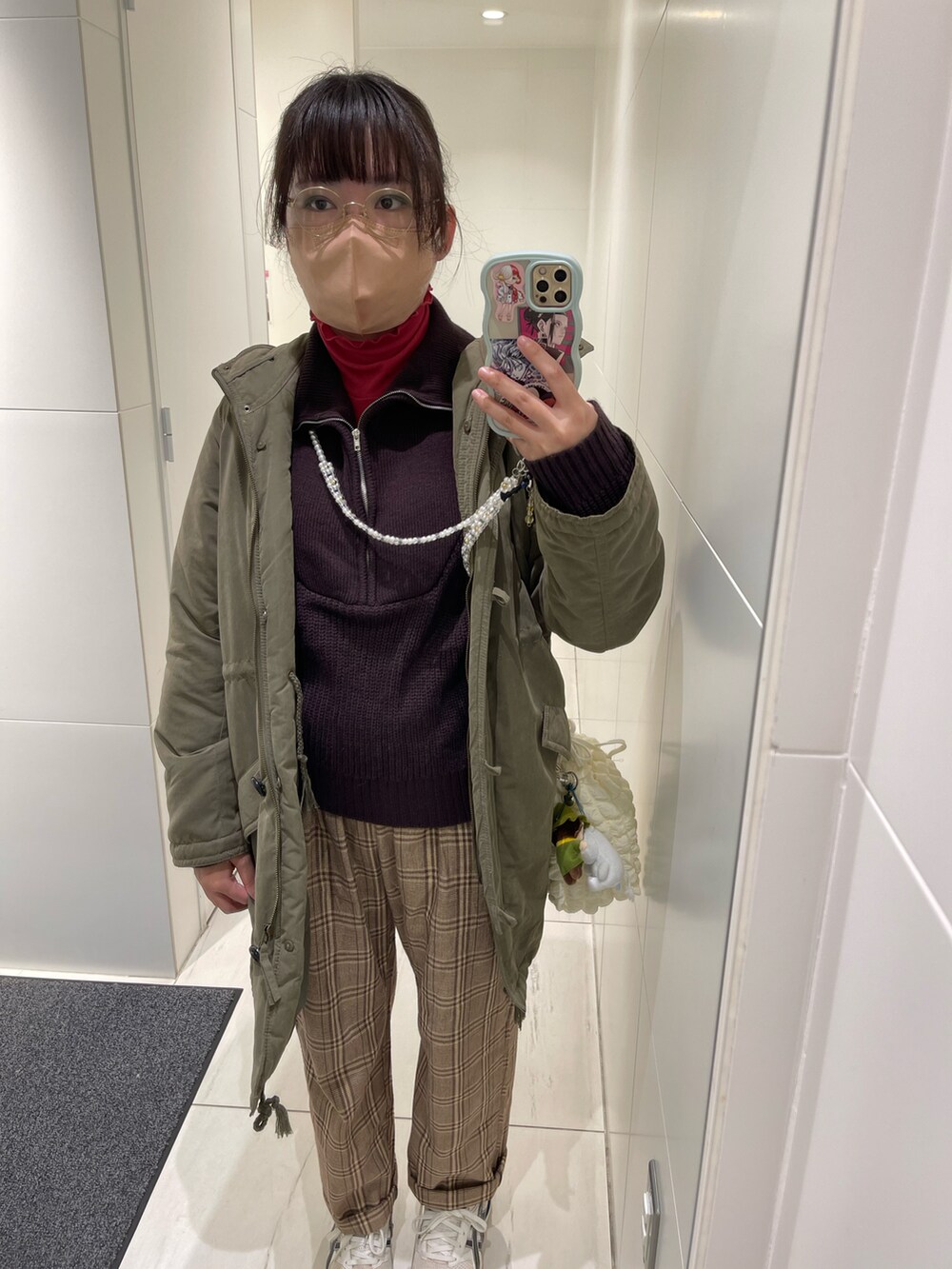 ベージュ系のカーゴパンツ、ホワイト系のスニーカー、ブラウン系のニット/セーターを着用したレディースの冬コーディネートの2枚目の写真