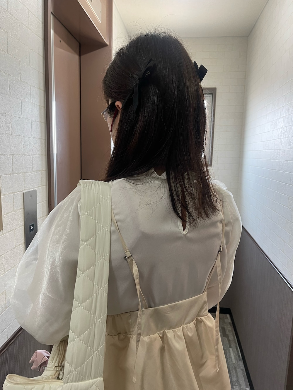 ブラウン系のベスト、ベージュ系のワンピース/ドレス、ブラック系のサンダルを着用したレディースの春コーディネートの2枚目の写真