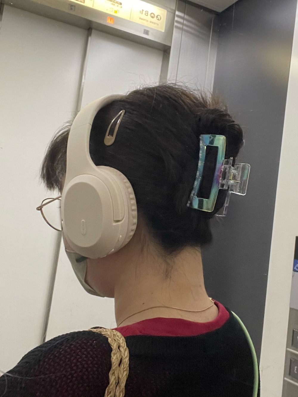 ブラウン系のデニムパンツ、ホワイト系のスニーカー、ブラック系のアンサンブルを着用したレディースの春コーディネートの2枚目の写真