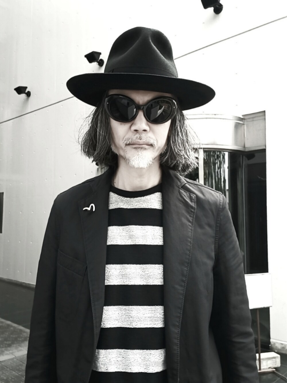 ブラック系のテーラードジャケット、ブラック系のスラックス、ブラック系のドレスシューズを着用したメンズの春コーディネートの4枚目の写真