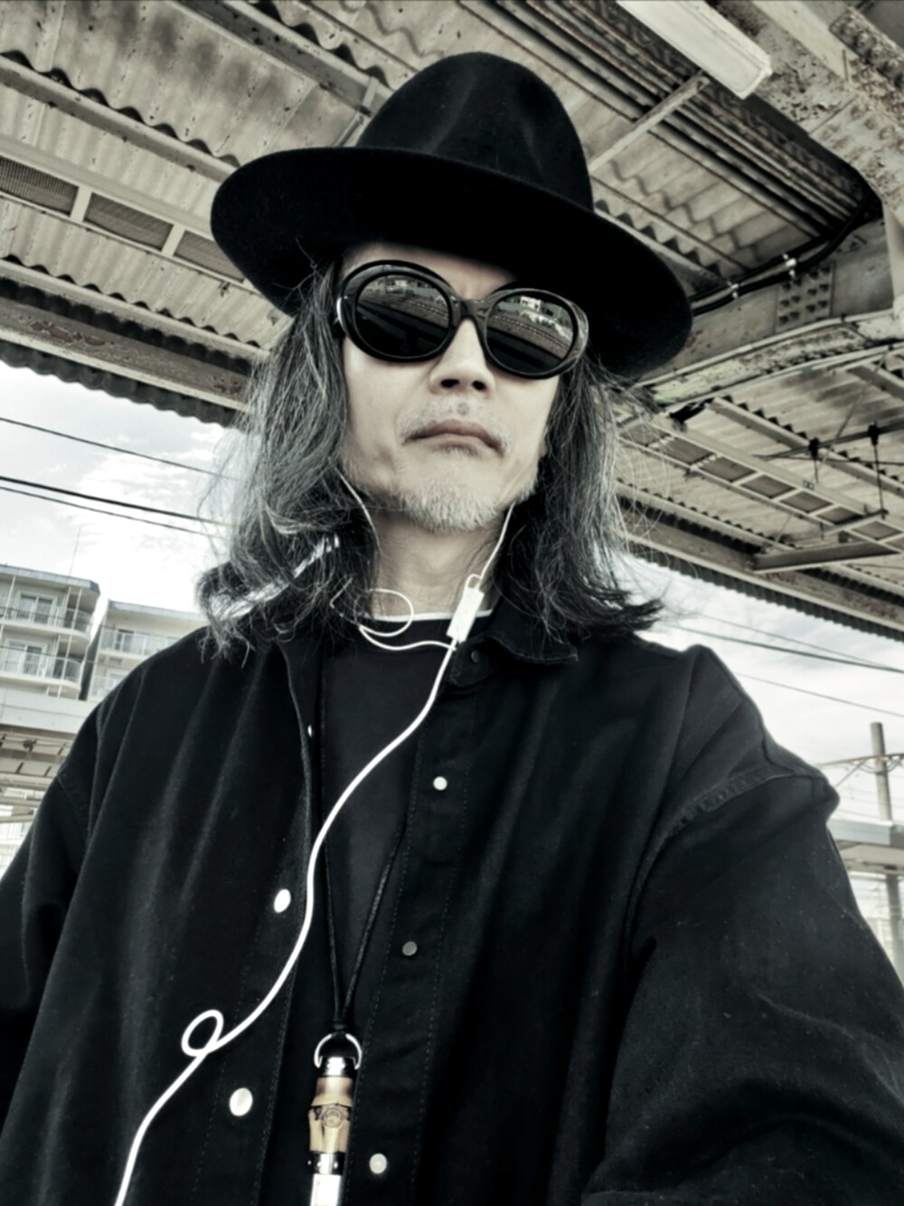 ブラック系のチノパンツ、ブラック系のTシャツ/カットソー、ブラック系のシャツ/ブラウスを着用したメンズの春コーディネートの4枚目の写真