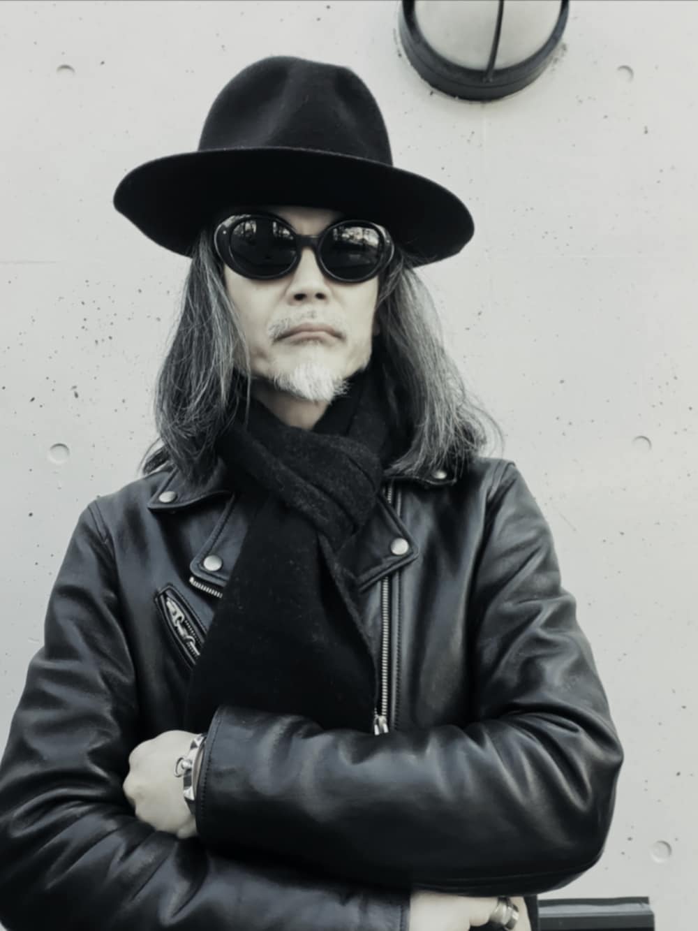 ブラック系のデニムパンツ、ブラック系のライダースジャケット、ブラック系のトートバッグを着用したメンズの冬コーディネートの2枚目の写真