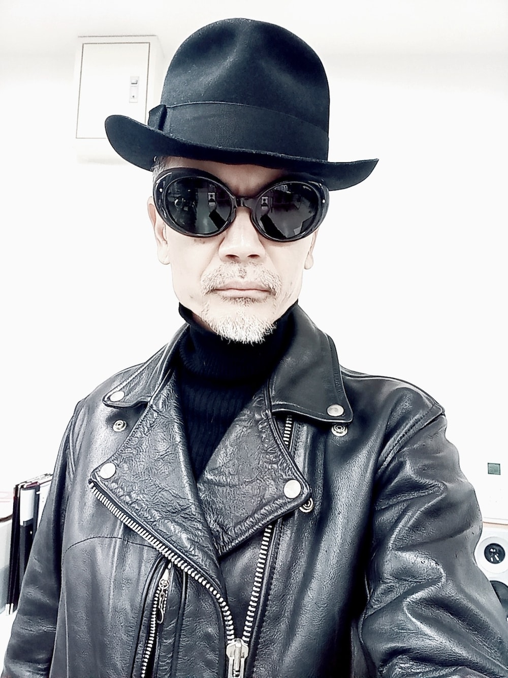 ブラック系のライダースジャケット、ブルー系のチノパンツ、ブラック系のブーツを着用したメンズの冬コーディネートの3枚目の写真