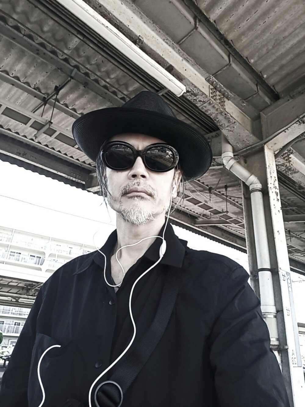 ブラック系のシャツ/ブラウス、ブルー系のデニムパンツ、ブラック系のスニーカーを着用したメンズの秋コーディネートの3枚目の写真