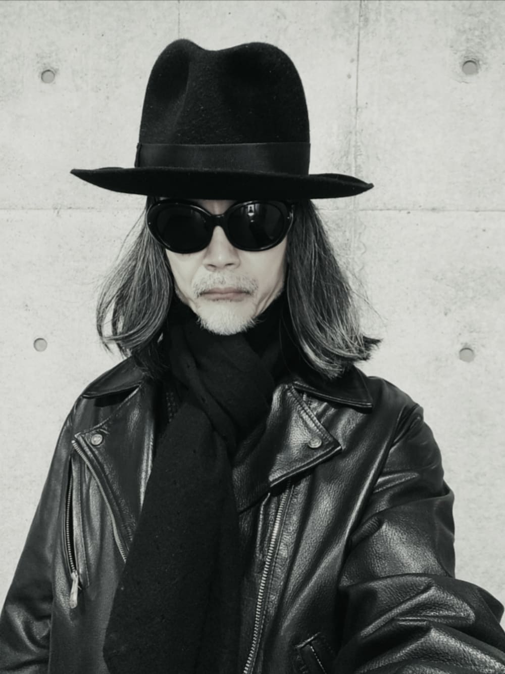 ブラック系のライダースジャケット、ブラック系のデニムパンツ、ブラック系のドレスシューズを着用したメンズの冬コーディネートの3枚目の写真