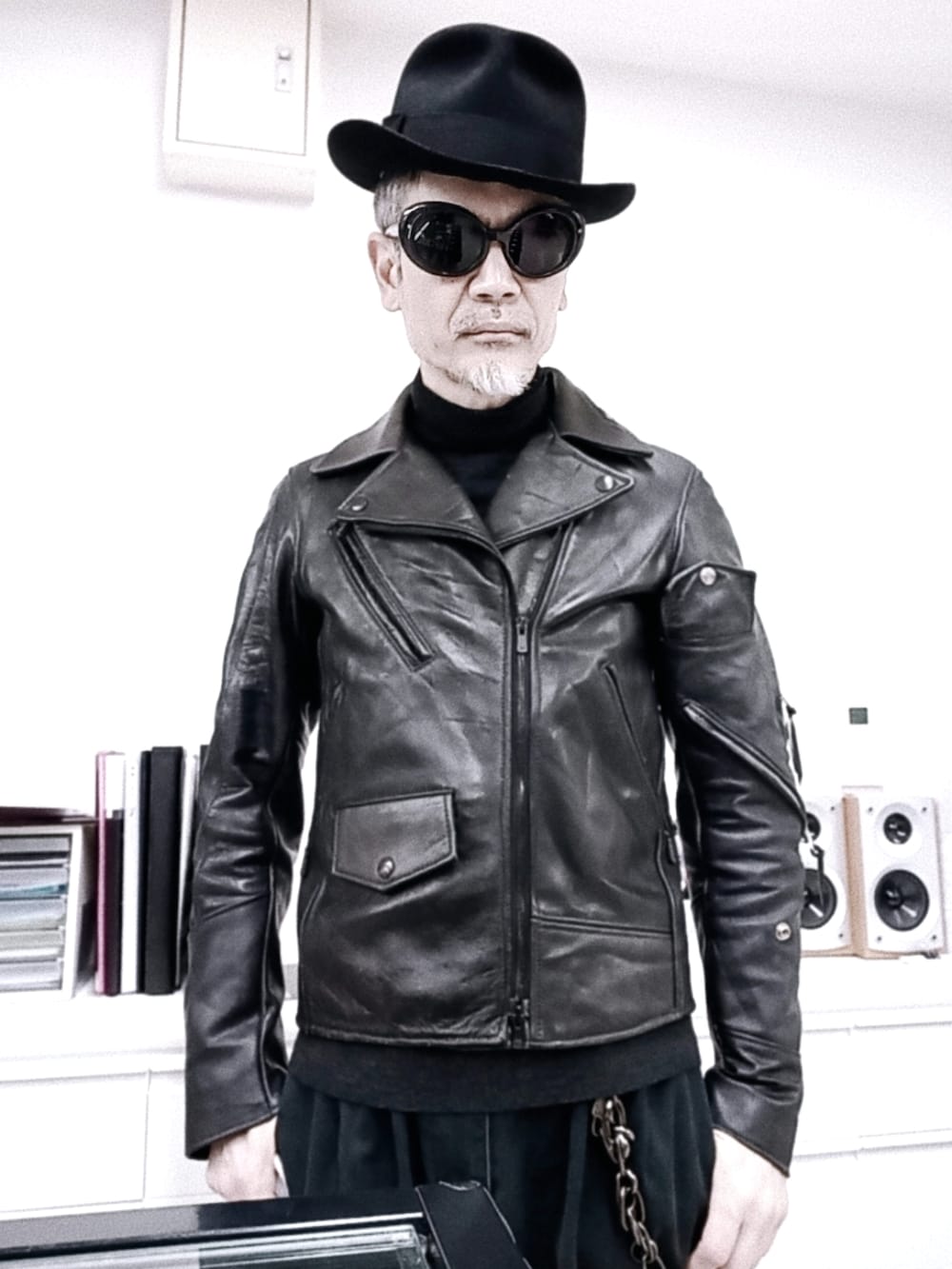 グレー系のチノパンツ、ブラック系のライダースジャケット、レッド系のブーツを着用したメンズの冬コーディネートの4枚目の写真