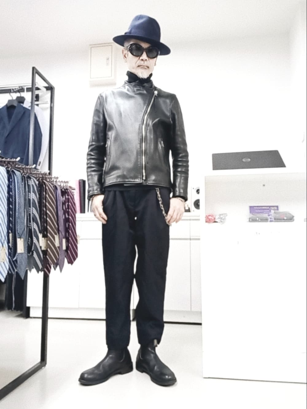 ブルー系のスラックス、ブラック系のライダースジャケット、ブラック系のブーツを着用したメンズの冬コーディネートの2枚目の写真