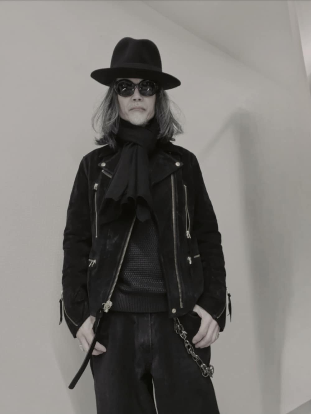 ブラック系のデニムパンツ、ブラック系のニット/セーター、ブラック系のドレスシューズを着用したメンズの冬コーディネートの2枚目の写真