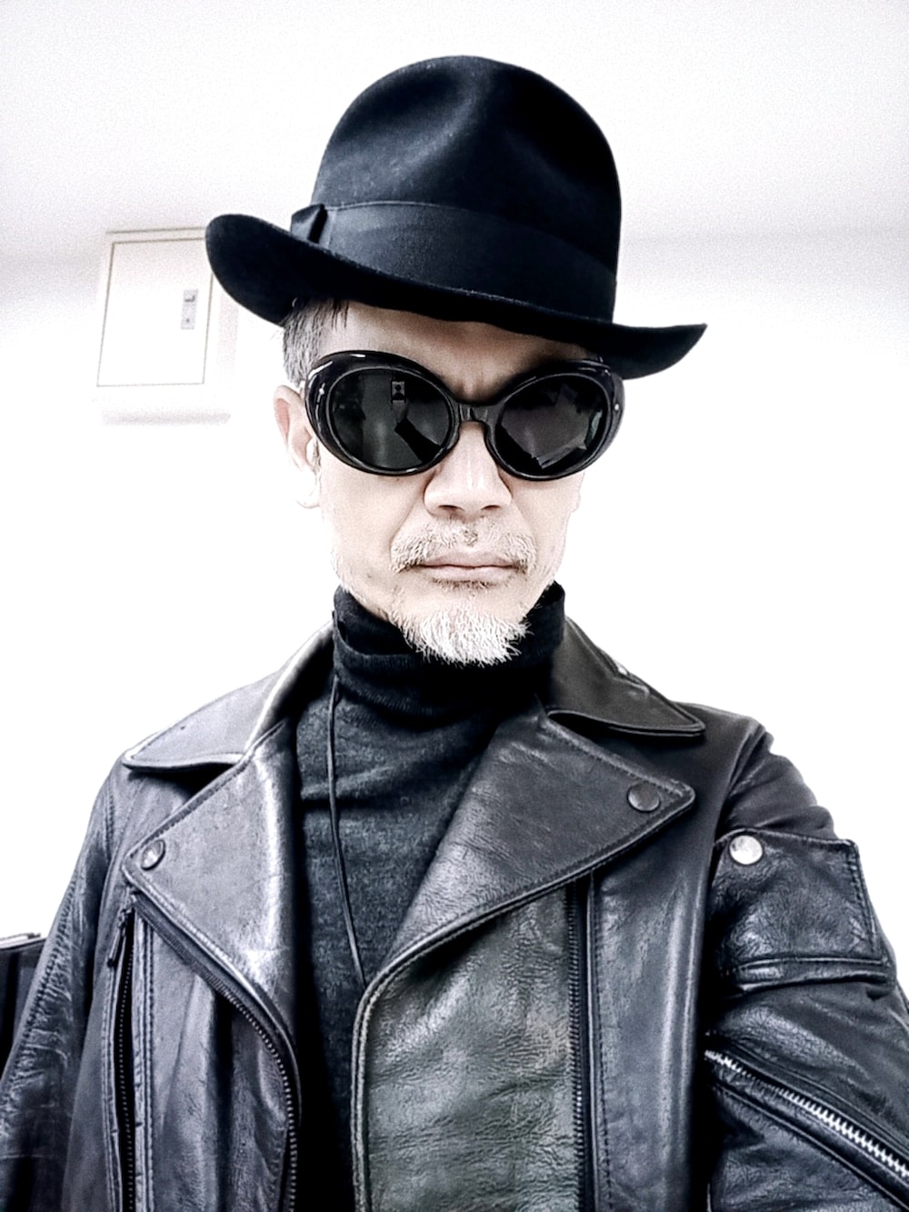 グレー系のチノパンツ、ブラック系のライダースジャケット、レッド系のブーツを着用したメンズの冬コーディネートの3枚目の写真