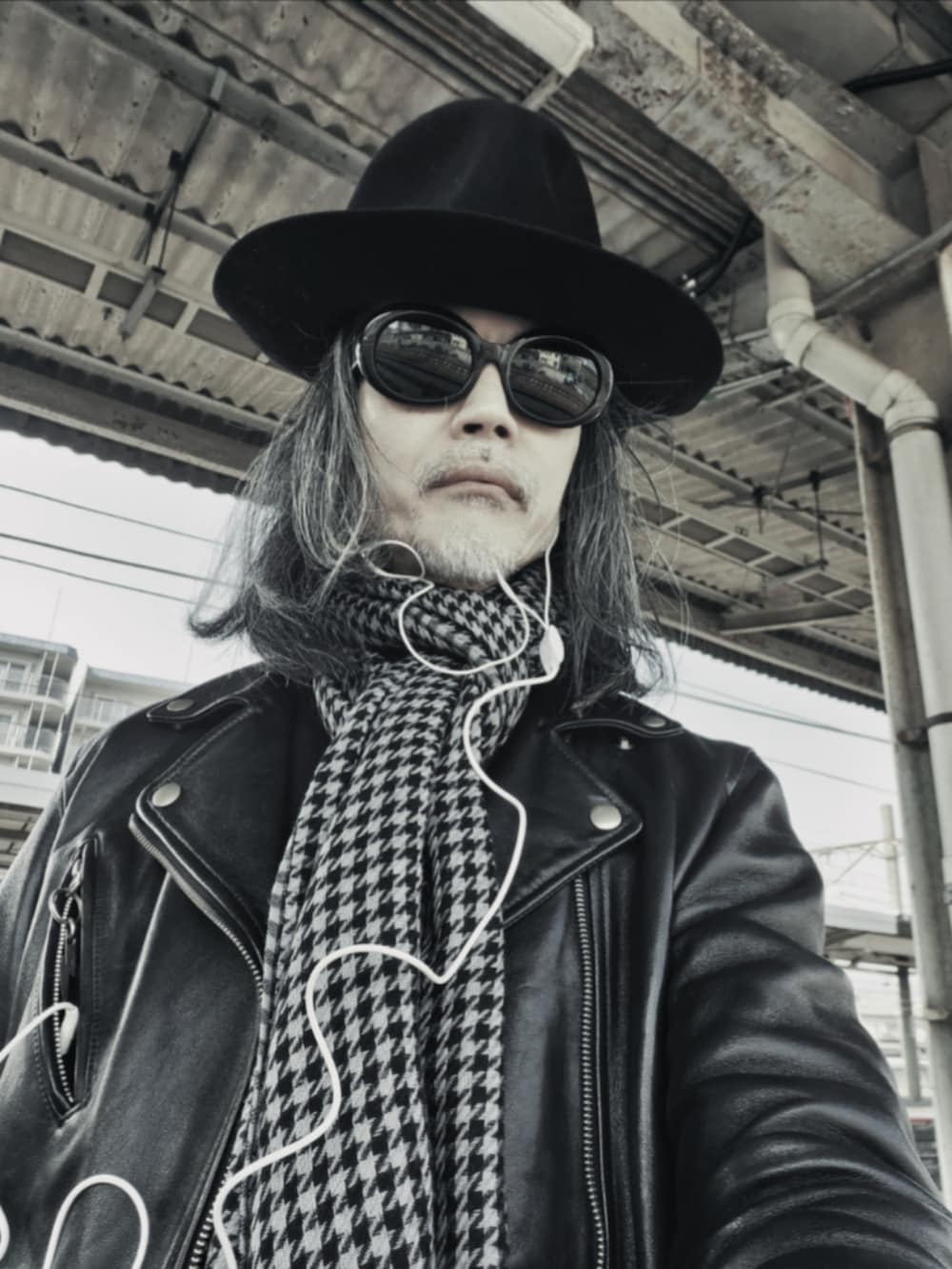 ブラック系のデニムパンツ、ブラック系のスニーカー、ブラック系のライダースジャケットを着用したメンズの春コーディネートの3枚目の写真