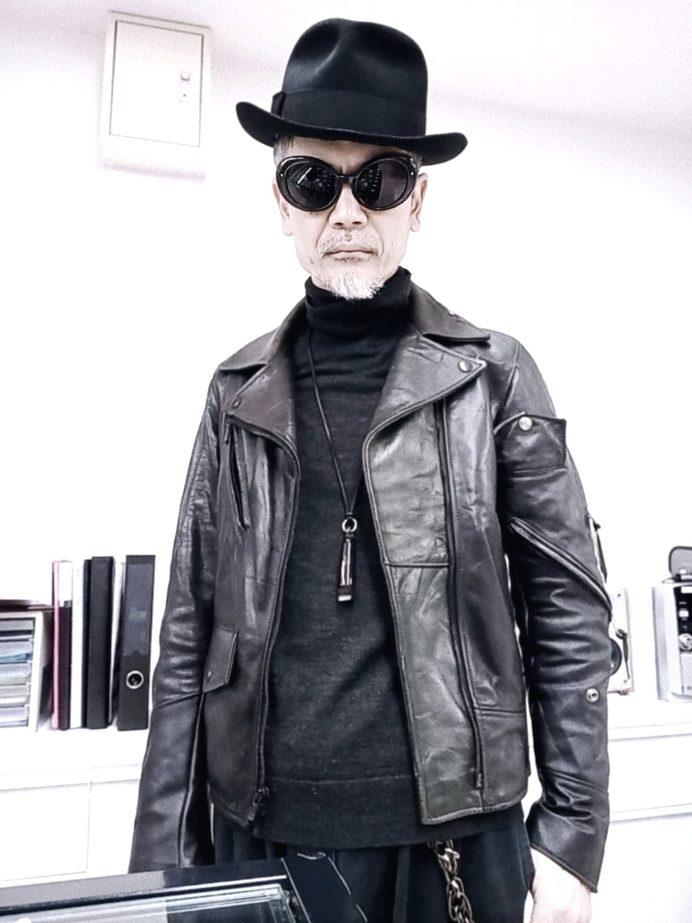 グレー系のチノパンツ、ブラック系のライダースジャケット、レッド系のブーツを着用したメンズの冬コーディネートの2枚目の写真