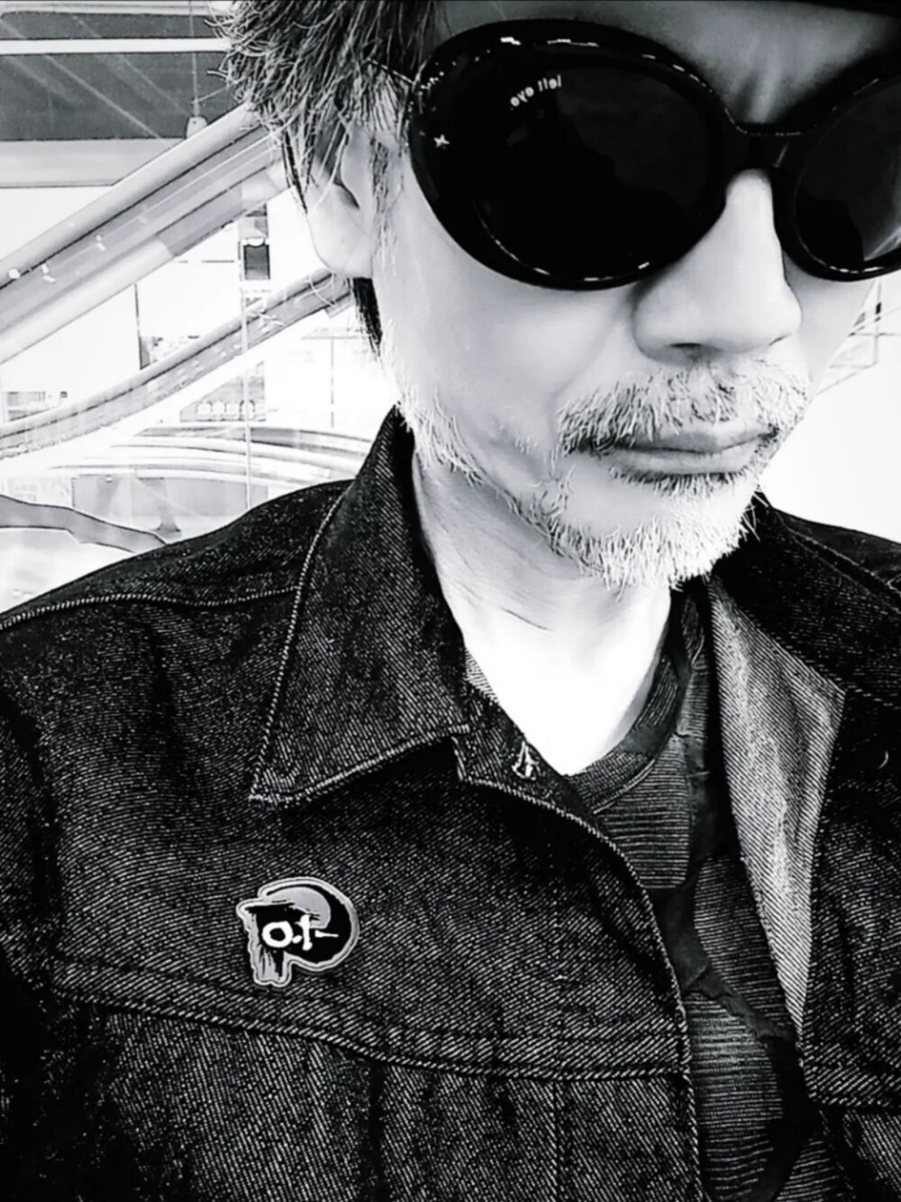 ブルー系のカーゴパンツ、ブラック系のデニムジャケット、ブラック系のブーツを着用したメンズの秋コーディネートの5枚目の写真