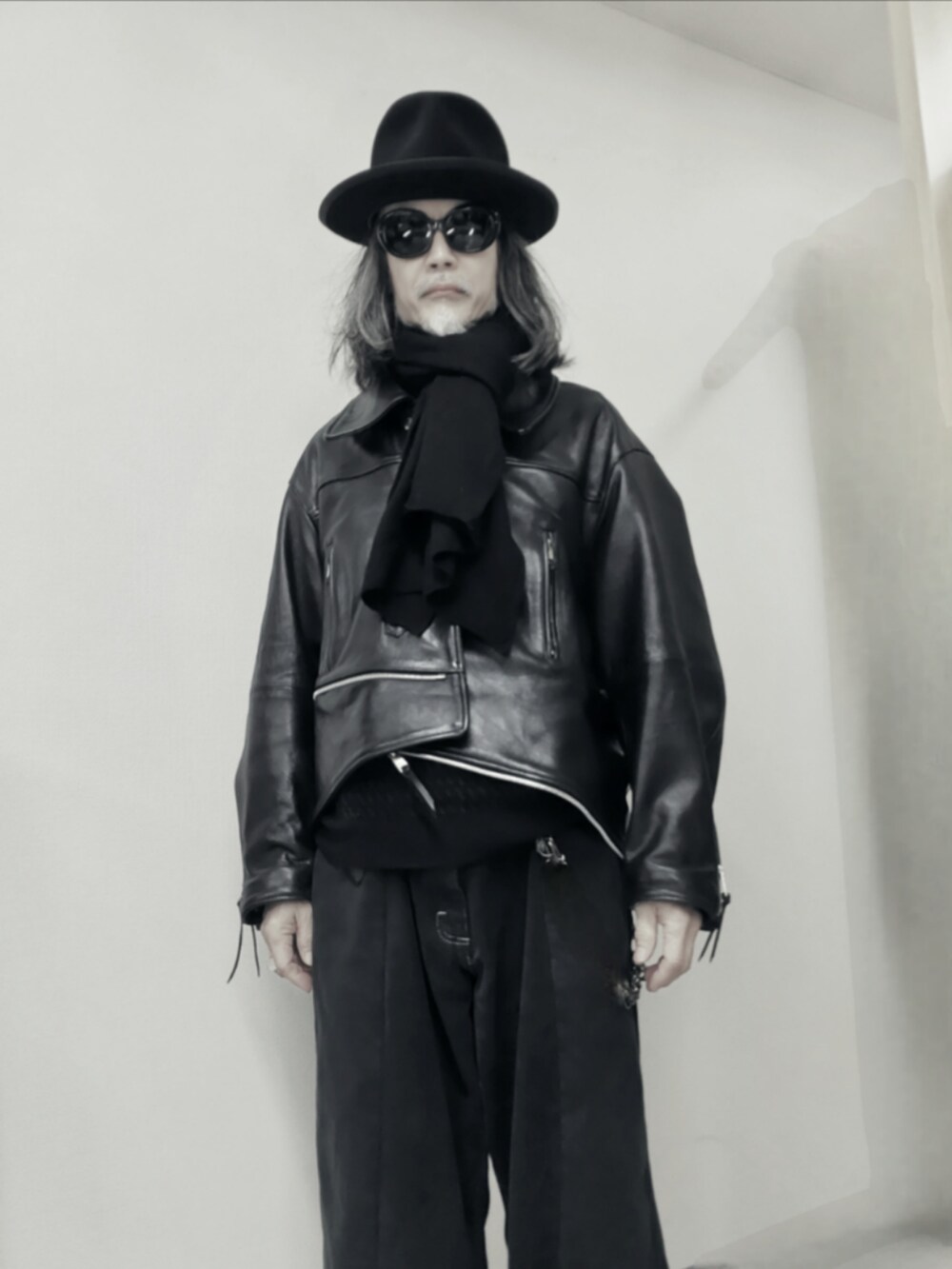 ブラック系のデニムパンツ、ブラック系のライダースジャケット、ブラック系のブーツを着用したメンズの冬コーディネートの2枚目の写真