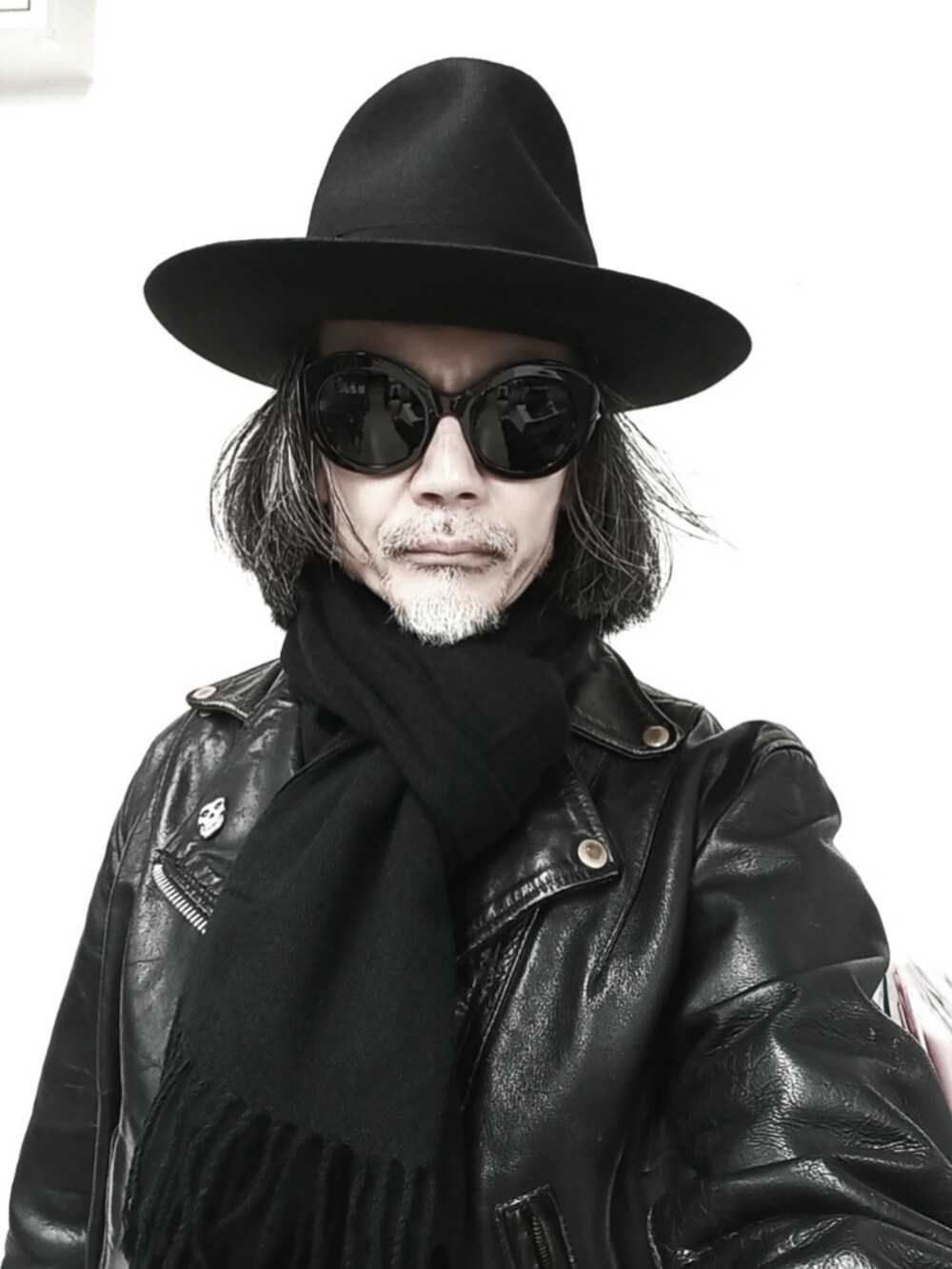 ブラック系のライダースジャケット、ブルー系のデニムパンツ、ブラック系のドレスシューズを着用したメンズの春コーディネートの3枚目の写真