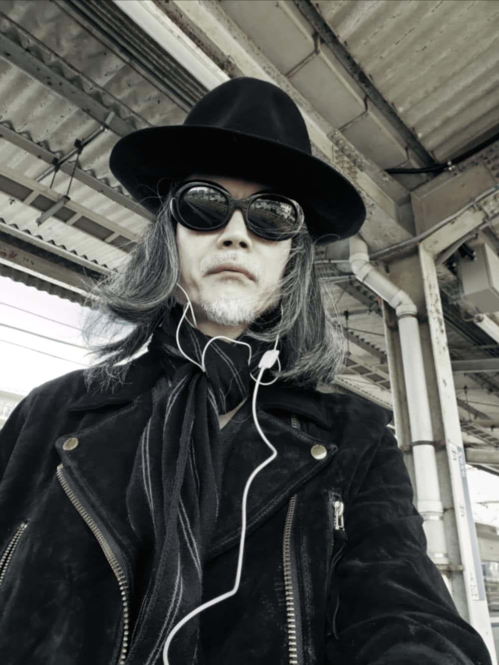 ブラック系のデニムパンツ、ブラック系のモカシン/デッキシューズ、ブラック系のライダースジャケットを着用したメンズの春コーディネートの4枚目の写真