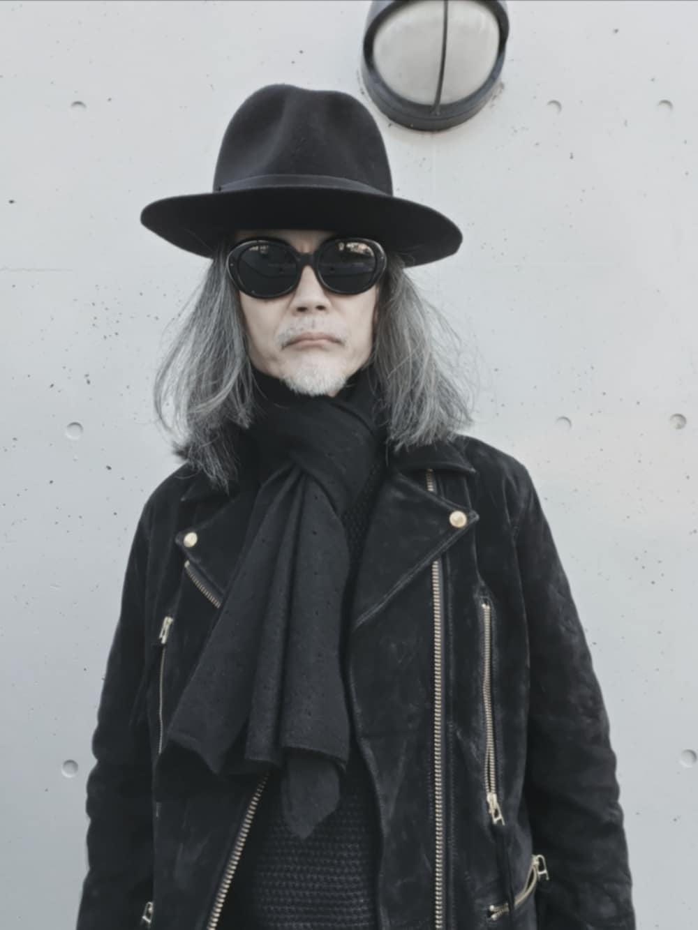 ブラック系のデニムパンツ、ブラック系のニット/セーター、ブラック系のドレスシューズを着用したメンズの冬コーディネートの3枚目の写真