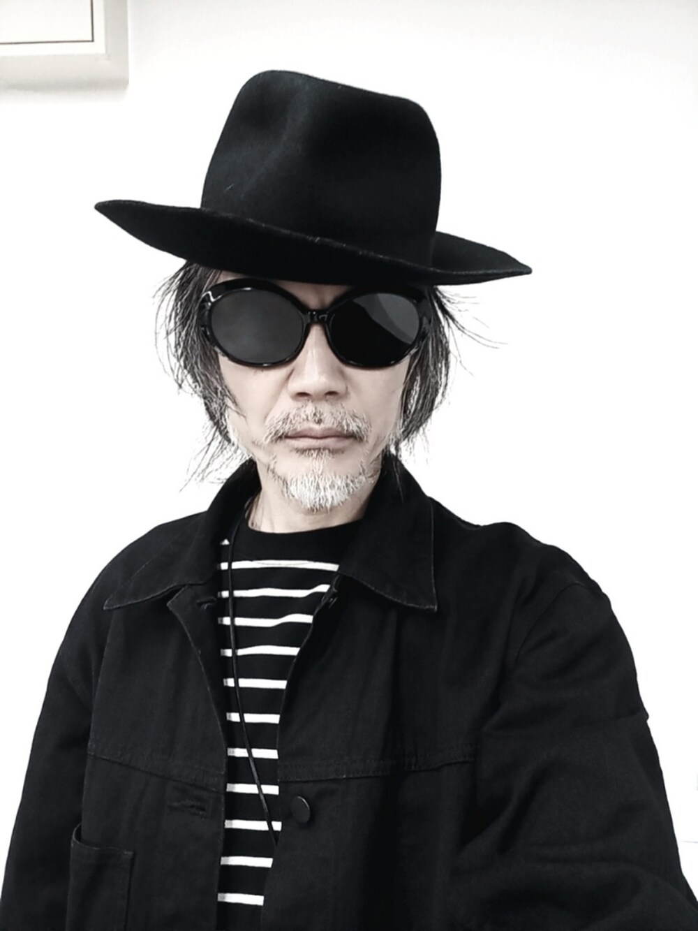 ブラック系のTシャツ/カットソー、ブラック系のカーゴパンツ、ブラック系のドレスシューズを着用したメンズの春コーディネートの5枚目の写真