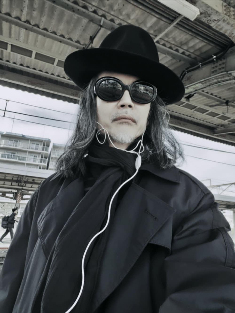 ブラック系のデニムパンツ、ブラック系のドレスシューズ、ブラック系のニット/セーターを着用したメンズの春コーディネートの4枚目の写真