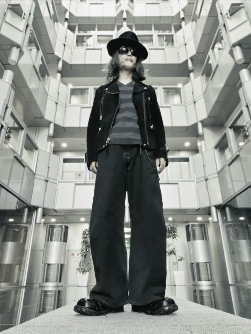 ブラック系のデニムパンツ、ブラック系のモカシン/デッキシューズ、ブラック系のライダースジャケットを着用したメンズの春コーディネートの2枚目の写真