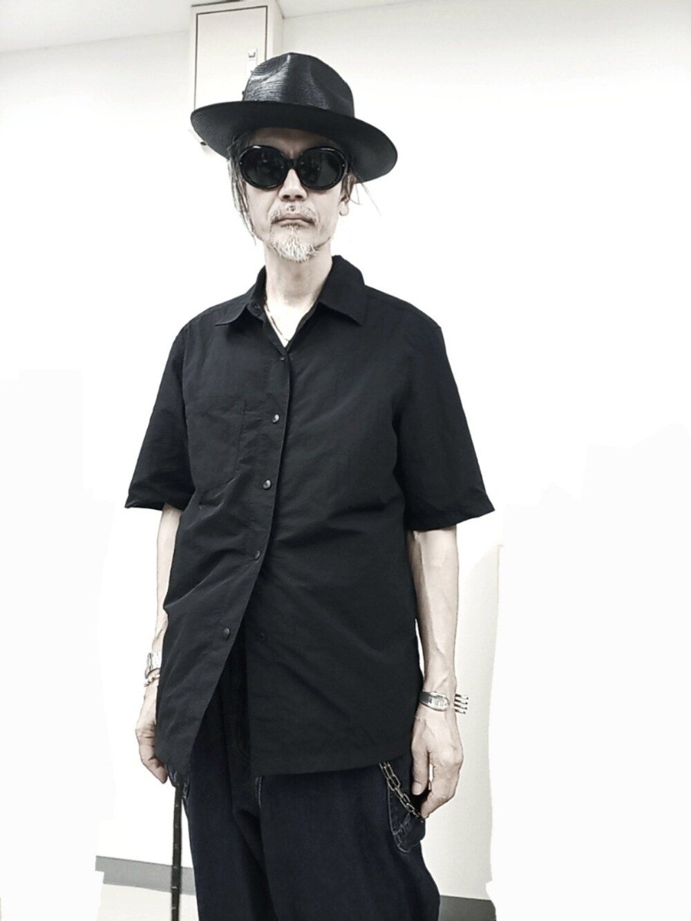 ブラック系のシャツ/ブラウス、ブルー系のデニムパンツ、ブラック系のスニーカーを着用したメンズの秋コーディネートの2枚目の写真