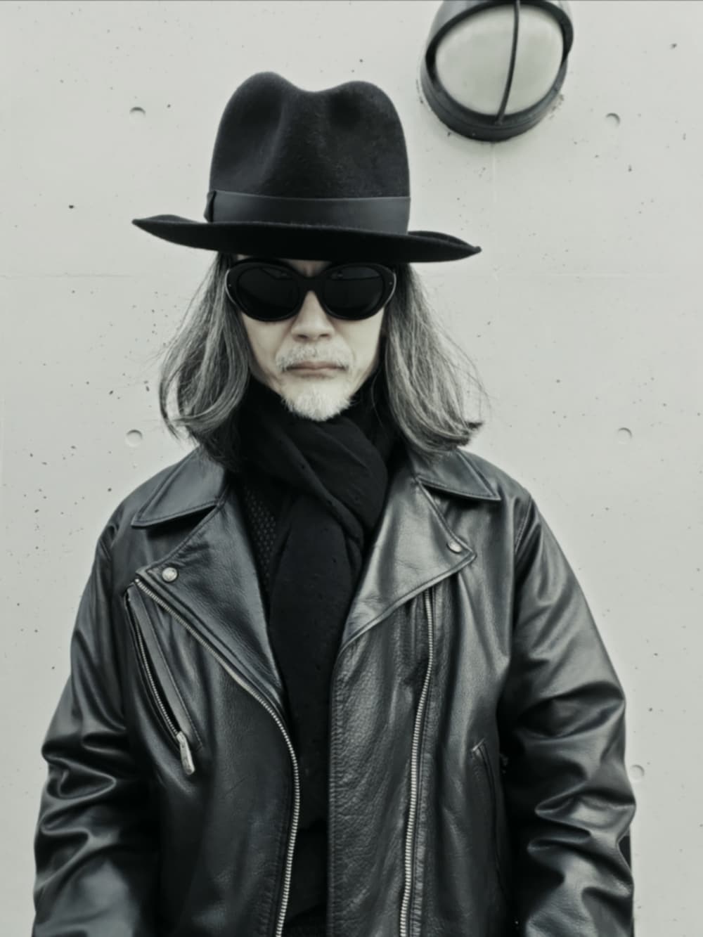 ブラック系のライダースジャケット、ブラック系のデニムパンツ、ブラック系のドレスシューズを着用したメンズの冬コーディネートの5枚目の写真