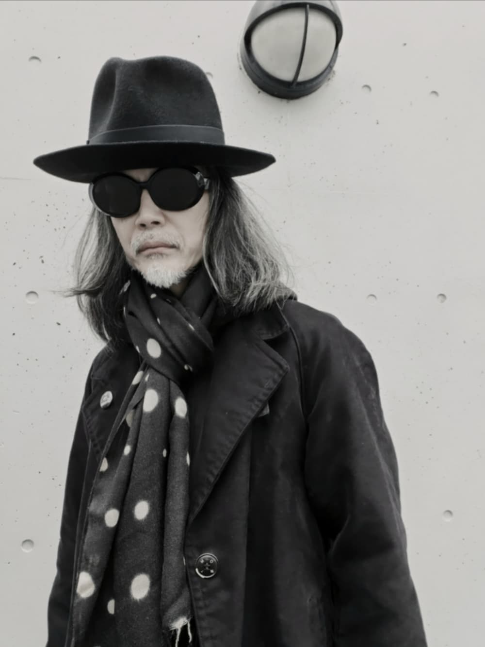 ブラック系のチェスターコート、ブラック系のデニムパンツ、ブラック系のドレスシューズを着用したメンズの冬コーディネートの2枚目の写真