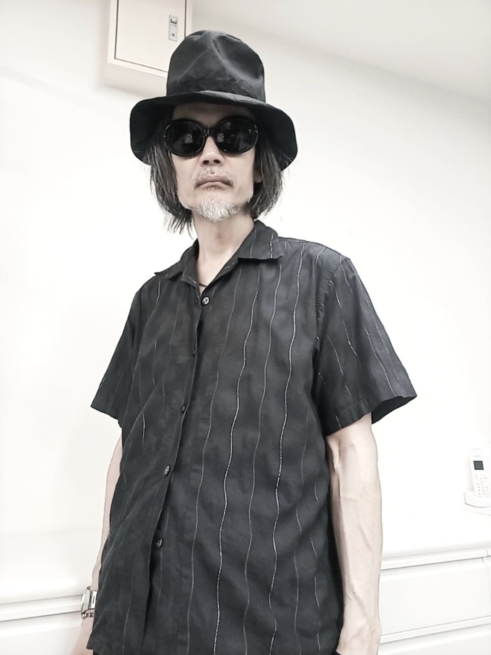 ブラック系のデニムパンツ、グレー系のシャツ/ブラウス、レッド系のブーツを着用したメンズの夏コーディネートの2枚目の写真