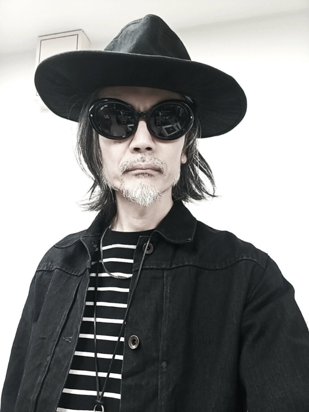 ブラック系のTシャツ/カットソー、ブラック系のデニムジャケット、ブラック系のデニムパンツを着用したメンズの秋コーディネートの2枚目の写真
