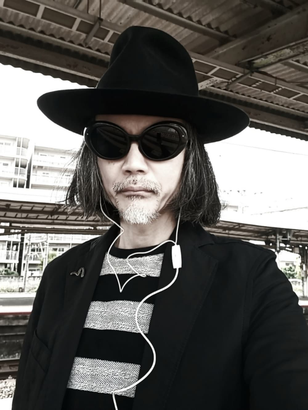 ブラック系のテーラードジャケット、ブラック系のスラックス、ブラック系のドレスシューズを着用したメンズの春コーディネートの5枚目の写真