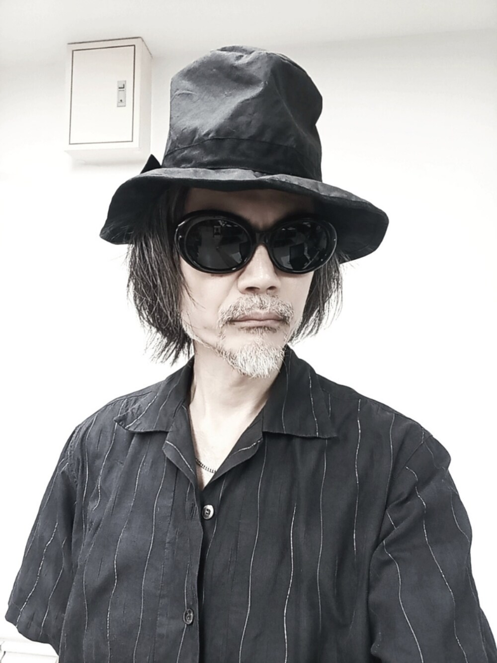 ブラック系のデニムパンツ、グレー系のシャツ/ブラウス、レッド系のブーツを着用したメンズの夏コーディネートの4枚目の写真