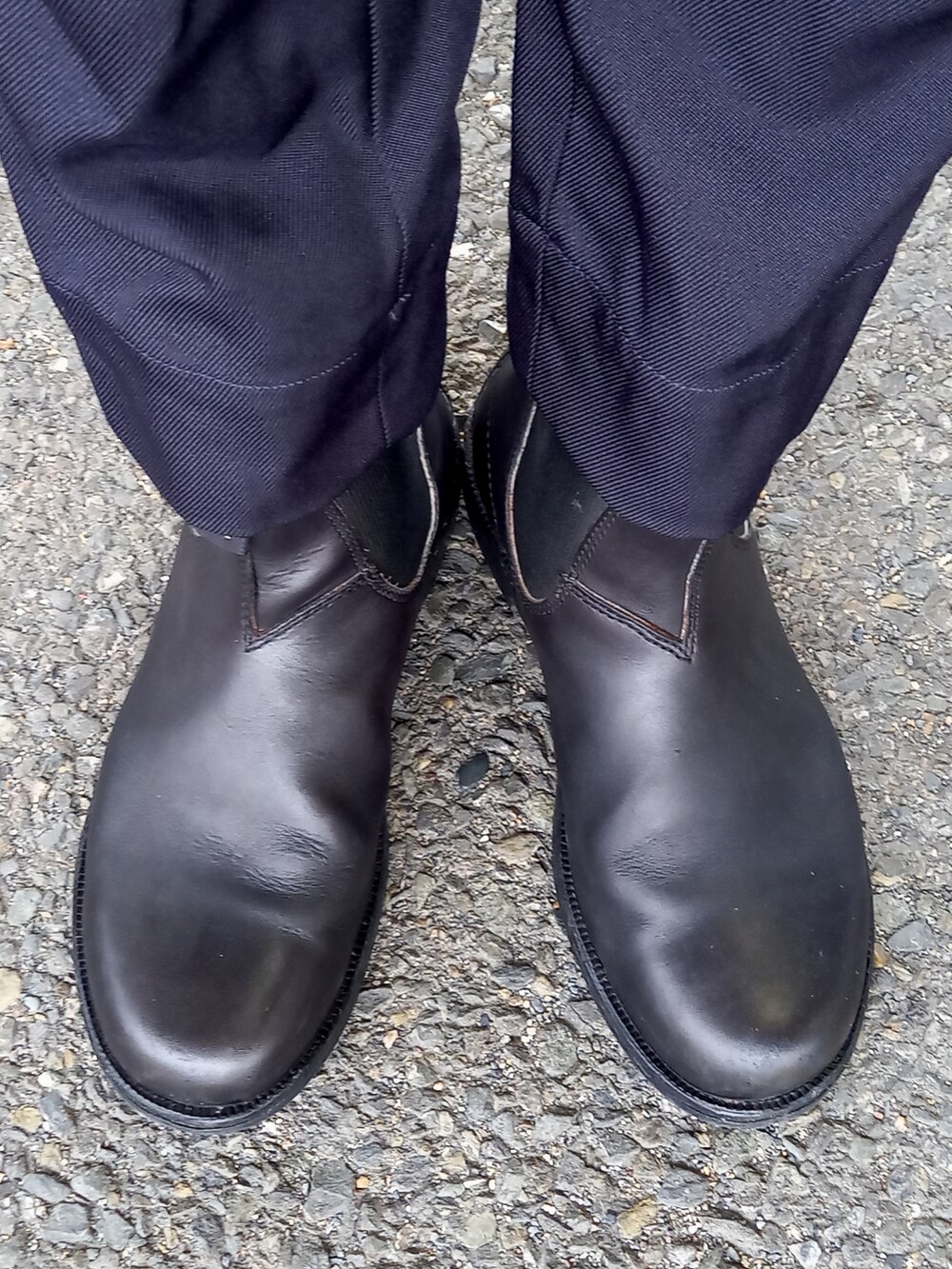 ブルー系のスラックス、ブラック系のライダースジャケット、ブラック系のブーツを着用したメンズの冬コーディネートの5枚目の写真